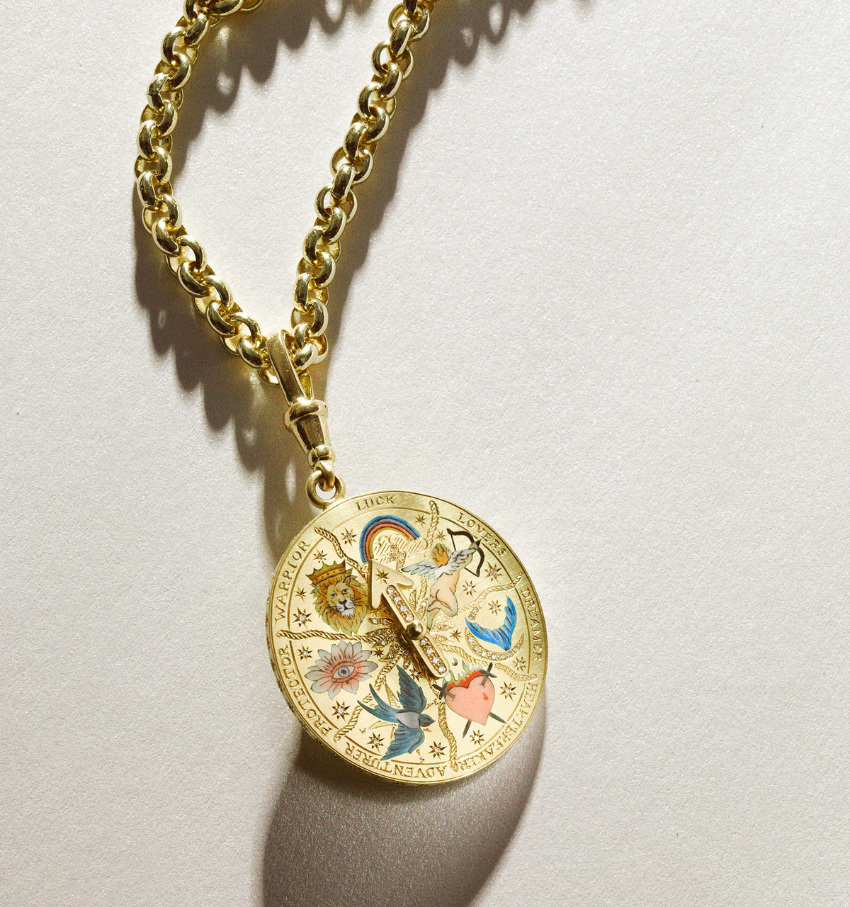 Gold pendant necklace featuring a colourful astrological motif and a chain link design.
