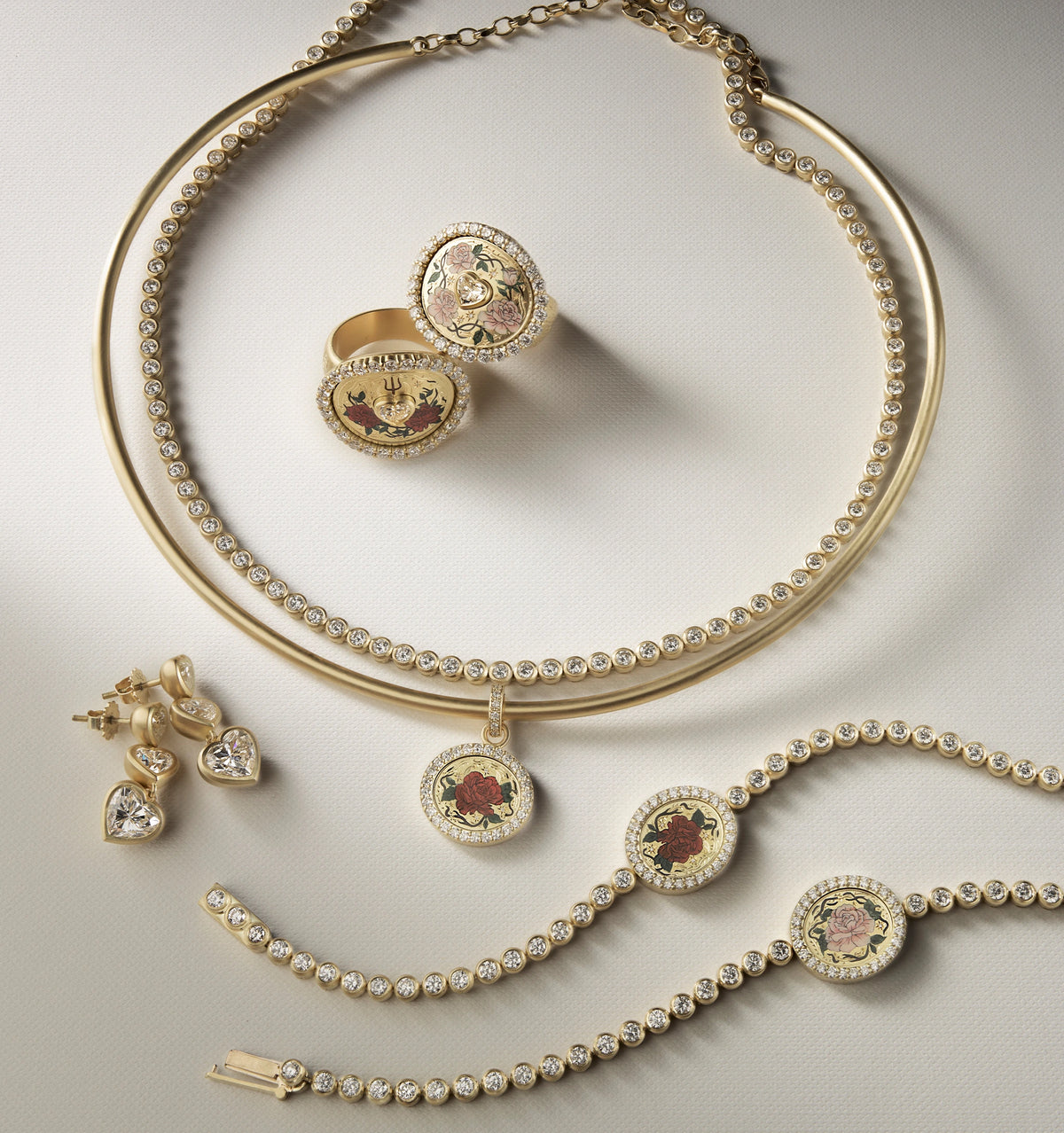 Gold jewellery set featuring an ornate ring, layered necklace, and bracelets with floral designs and diamonds.