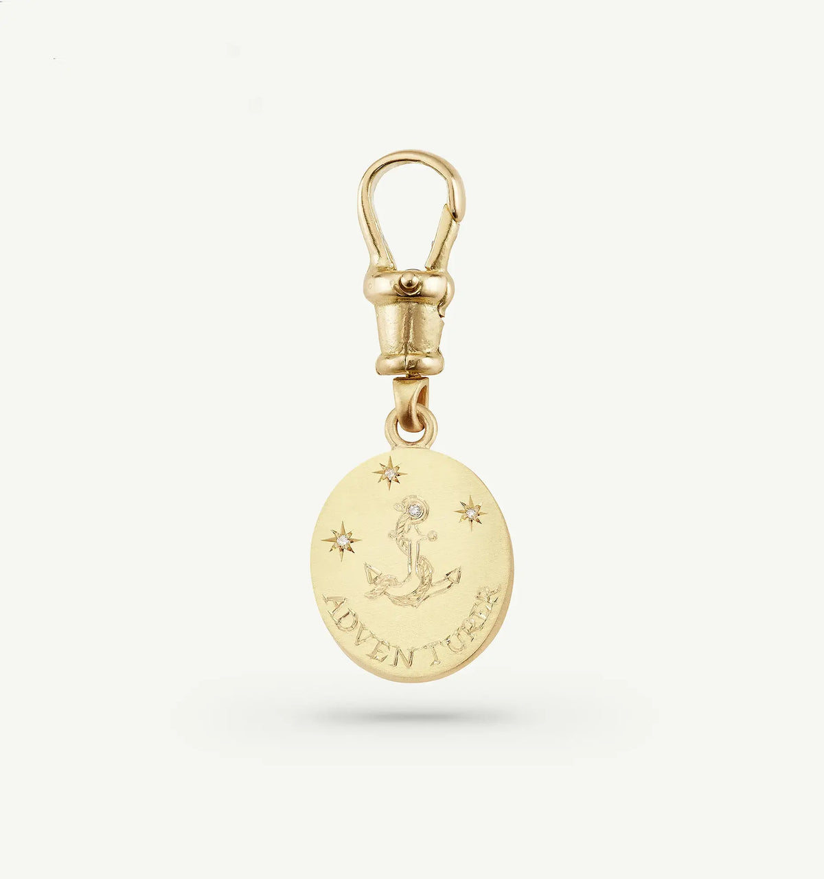 Gold charm featuring an anchor design and engraved 'ADVENTURER' with a diamond accent and star motifs.