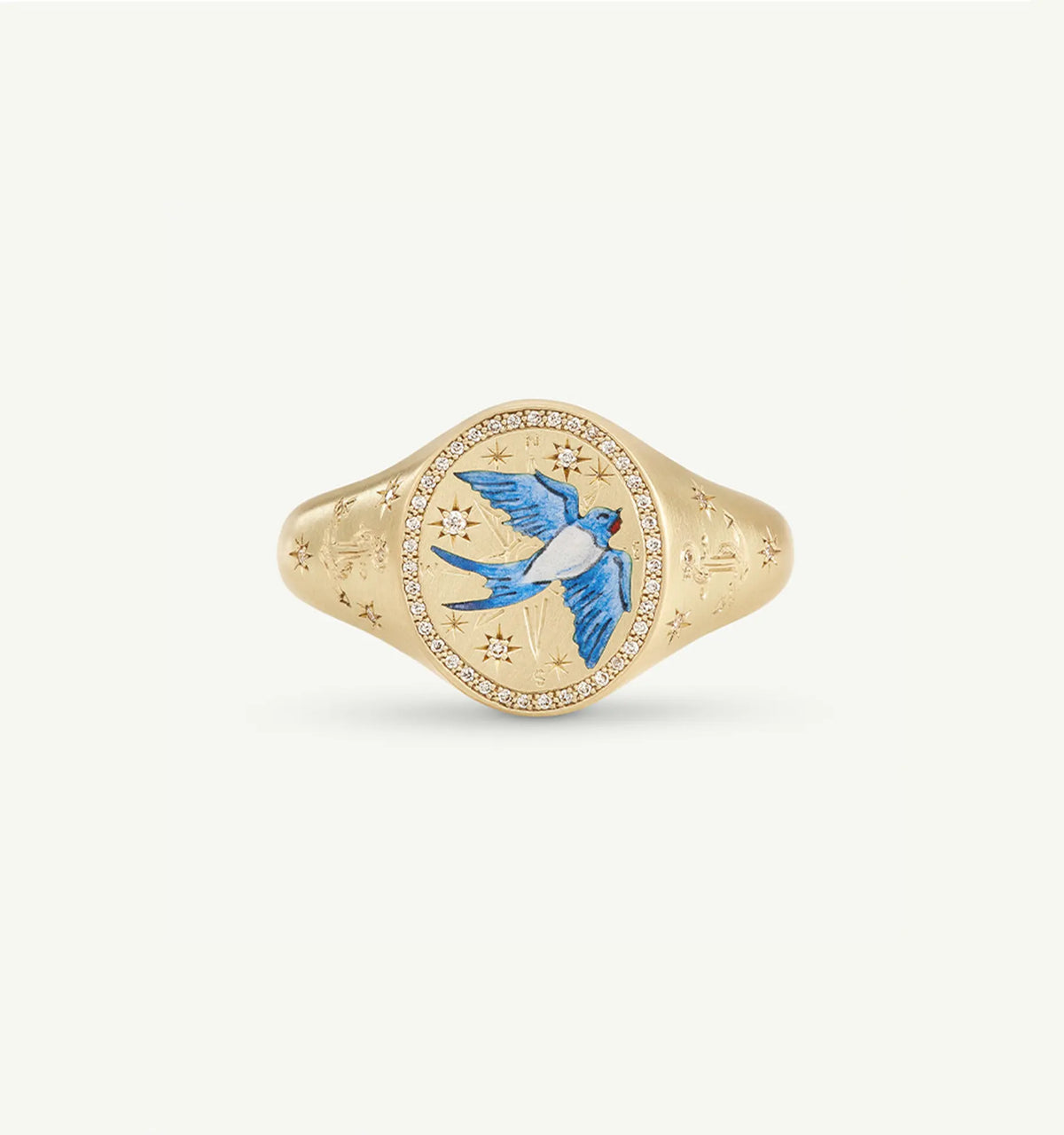 Gold signet ring featuring a blue bird motif in enamel and surrounded by a circle of white diamonds.