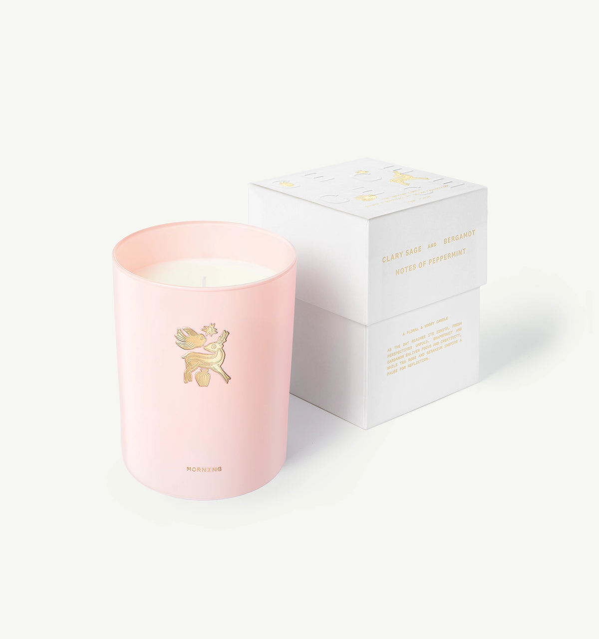 Wearing a pink candle jar featuring a decorative gold emblem with a box labelled "Clary Sage and Bergamot."