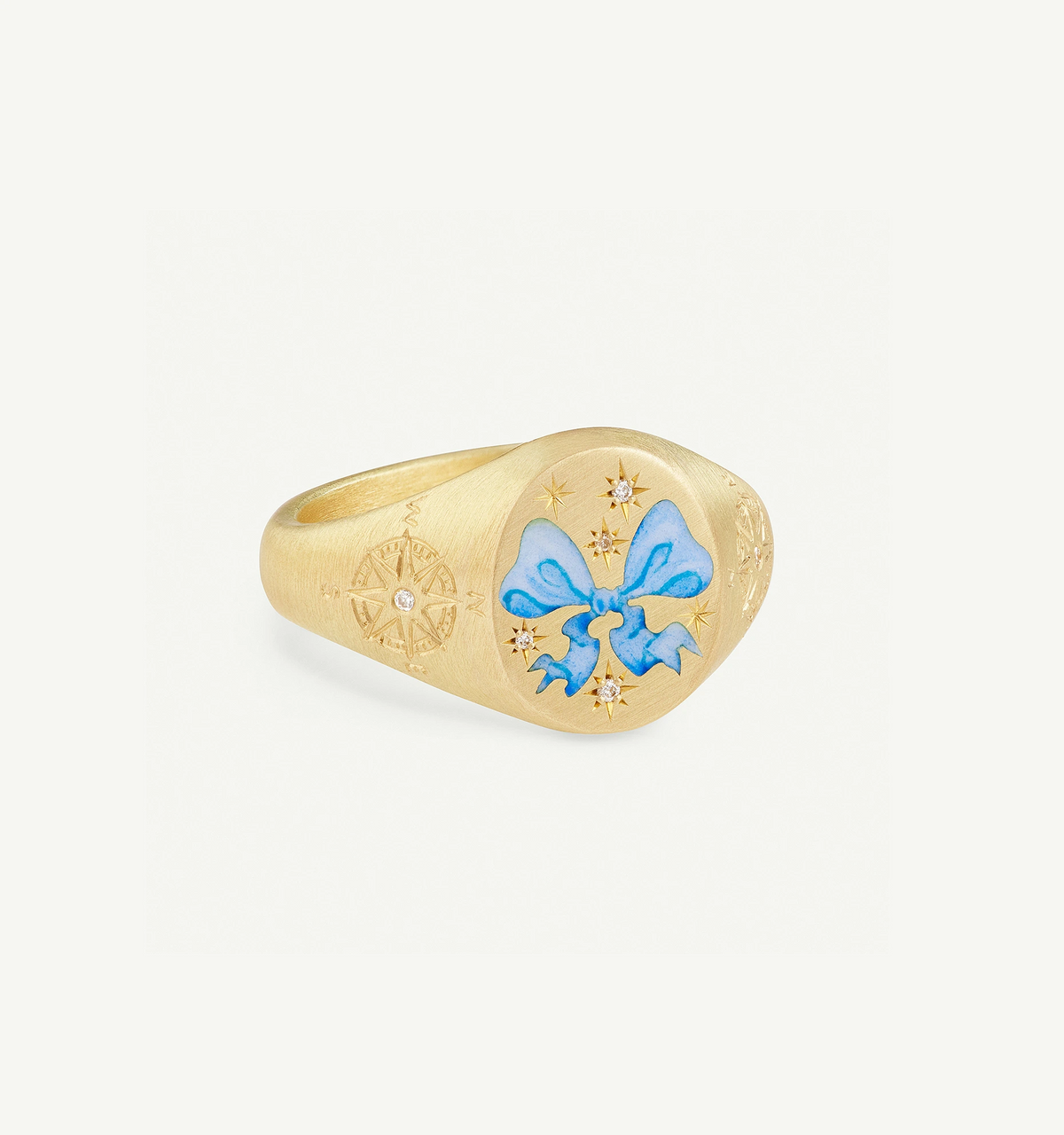 Gold ring featuring a blue enamel bow and star engravings with a diamond accent.