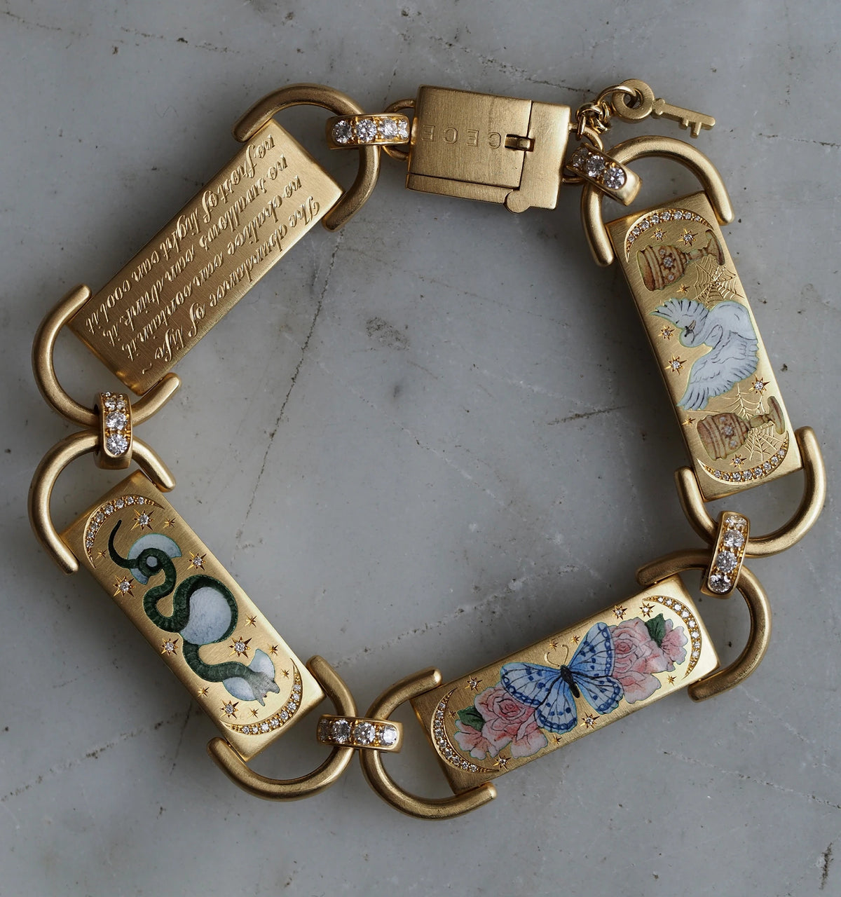 Gold bracelet with engraved panels featuring a snake, bird, and butterfly designs, accented with diamonds.