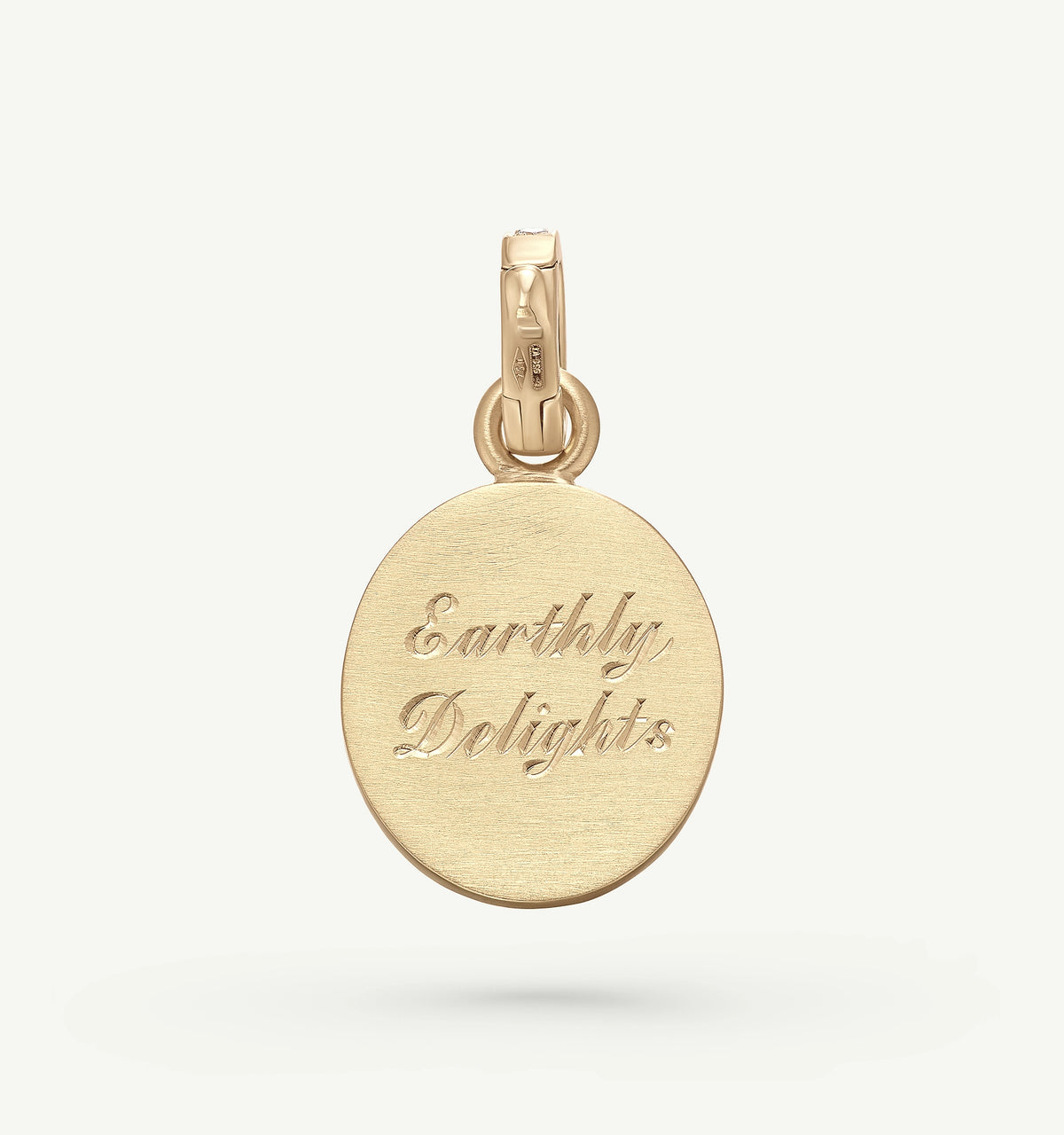 Gold pendant featuring engraved text "Earthly Delights" on a brushed surface.