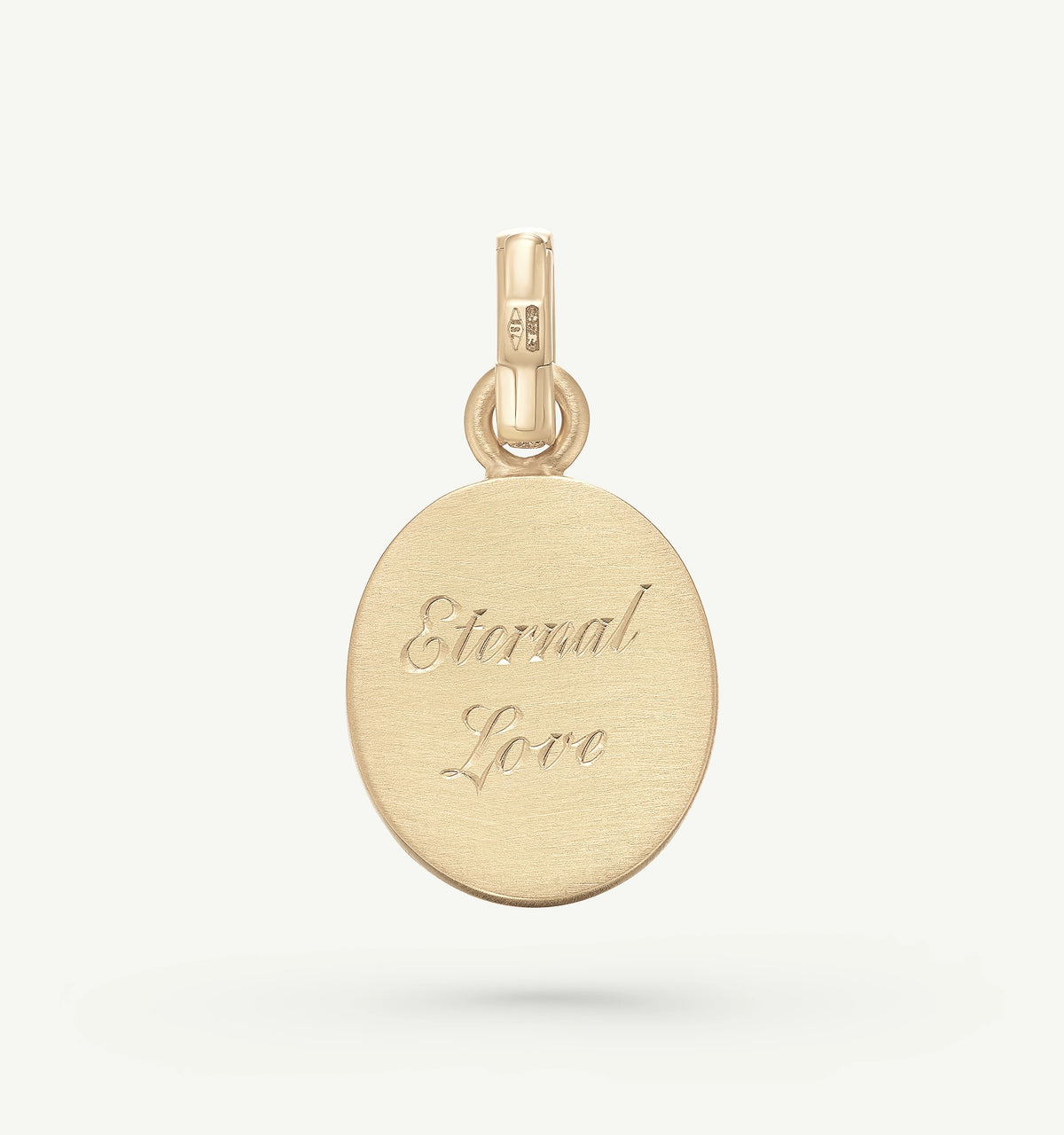 Gold pendant featuring the engraved text "Eternal Love."