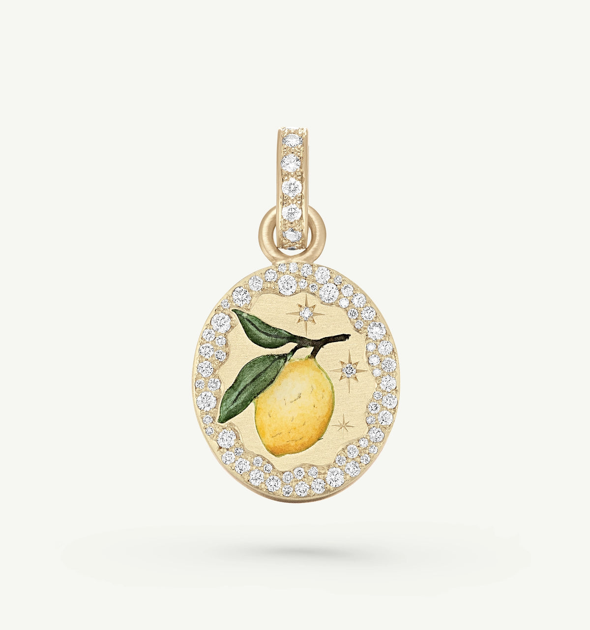 Gold pendant featuring a lemon design in enamel, surrounded by a circular border of diamonds.