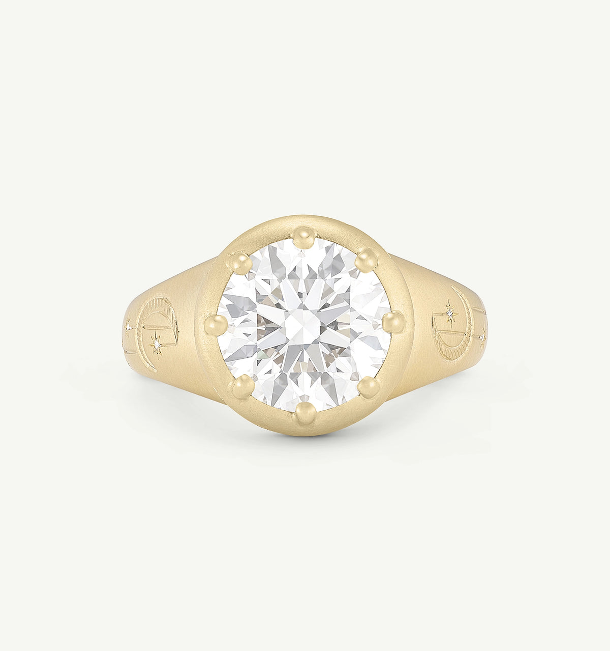Gold ring featuring a round diamond set within a textured band with engraved celestial motifs.