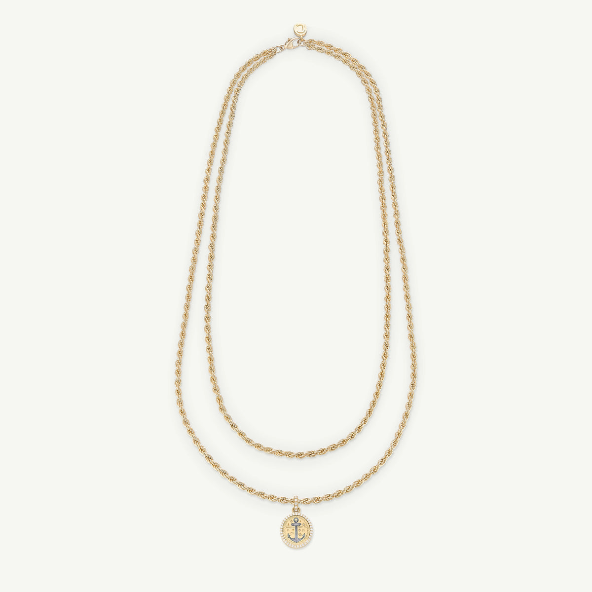 Gold necklace with a two-strand twisted design and circular anchor charm pendant.