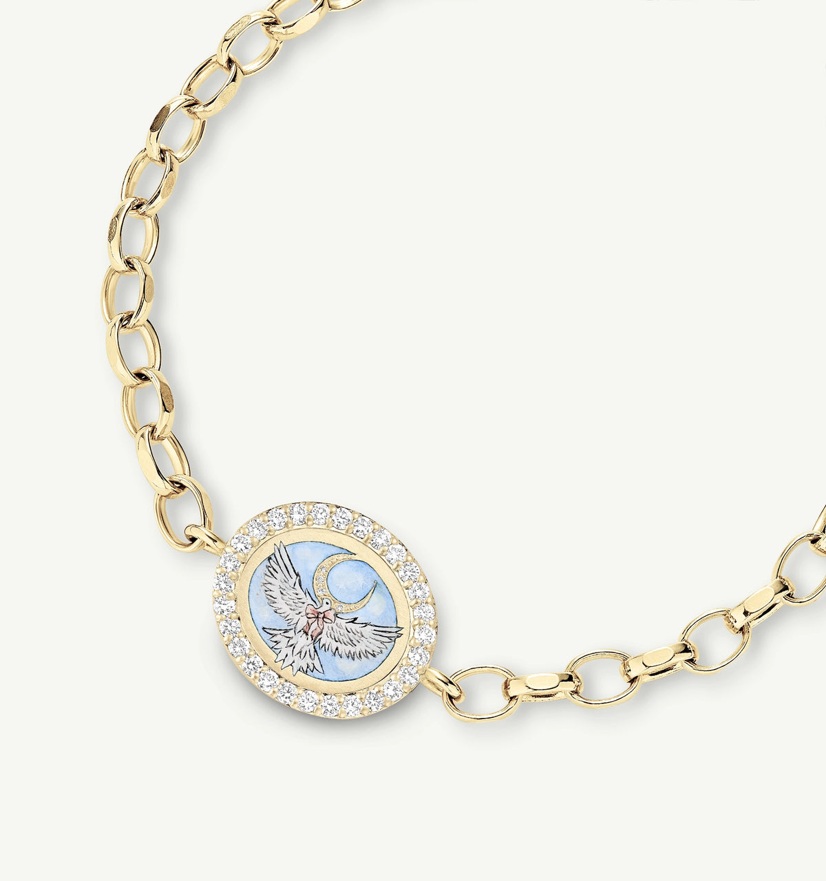 Gold bracelet featuring an oval charm with an engraved dove and moon design, accented by diamonds.