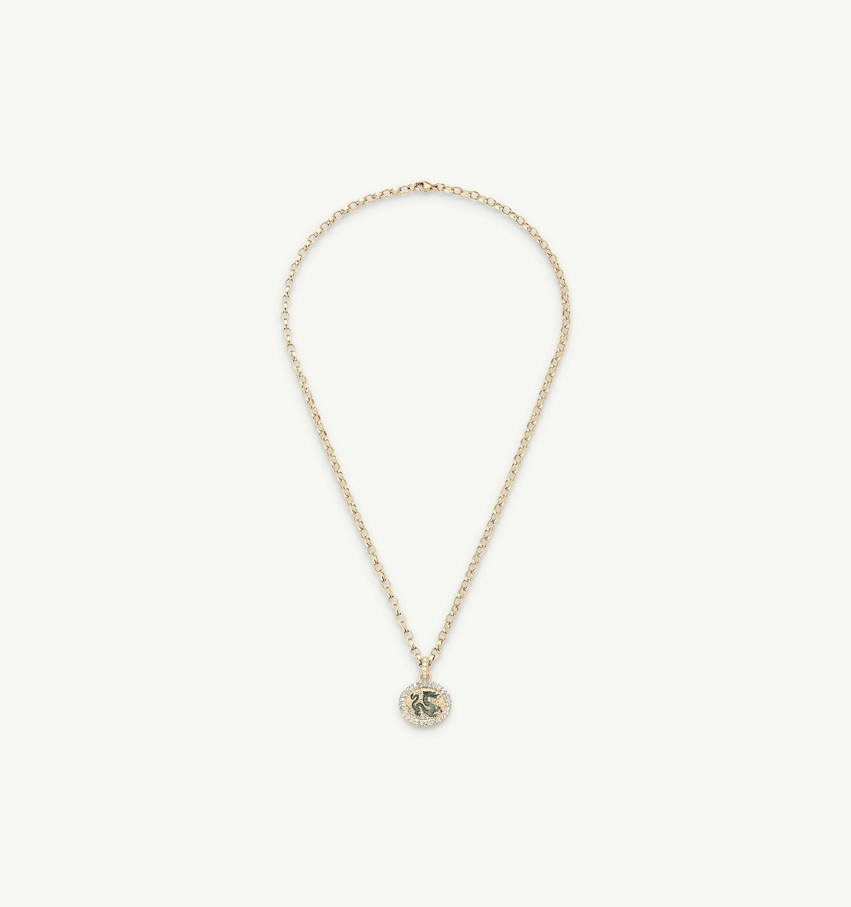 Gold necklace featuring a circular pendant with an engraved design and a delicate chain.