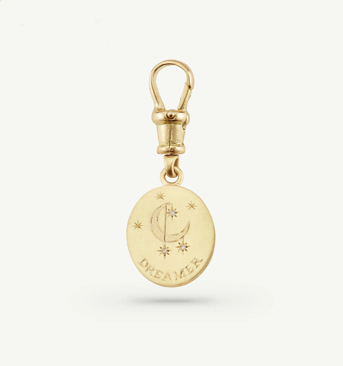 Gold pendant featuring an engraved crescent moon and stars with the word "DREAMER" at the bottom.