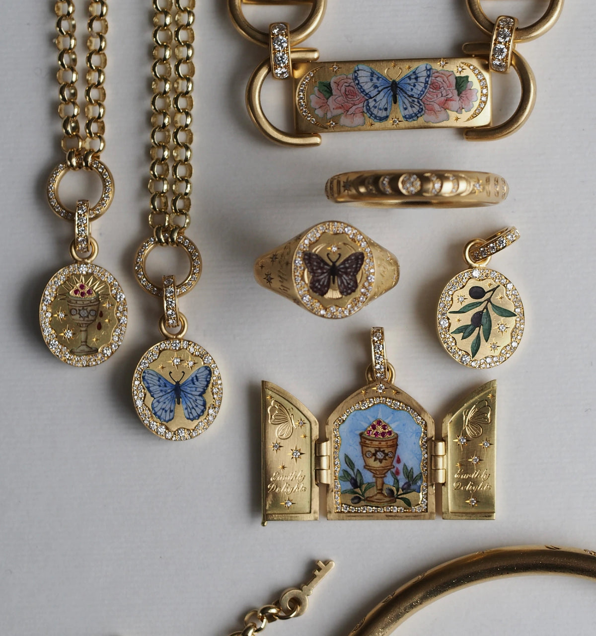 Gold jewellery collection featuring detailed enamel designs with butterflies, flowers, and ornate motifs.
