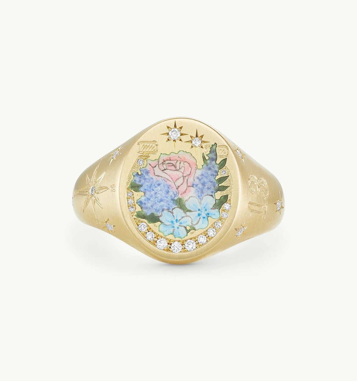 Gold signet ring featuring a painted floral design surrounded by diamonds and engraved star motifs.