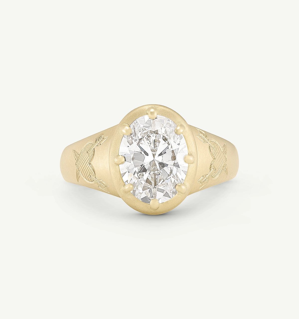 Gold ring featuring an oval diamond centre stone with engraved bird motifs on the band.
