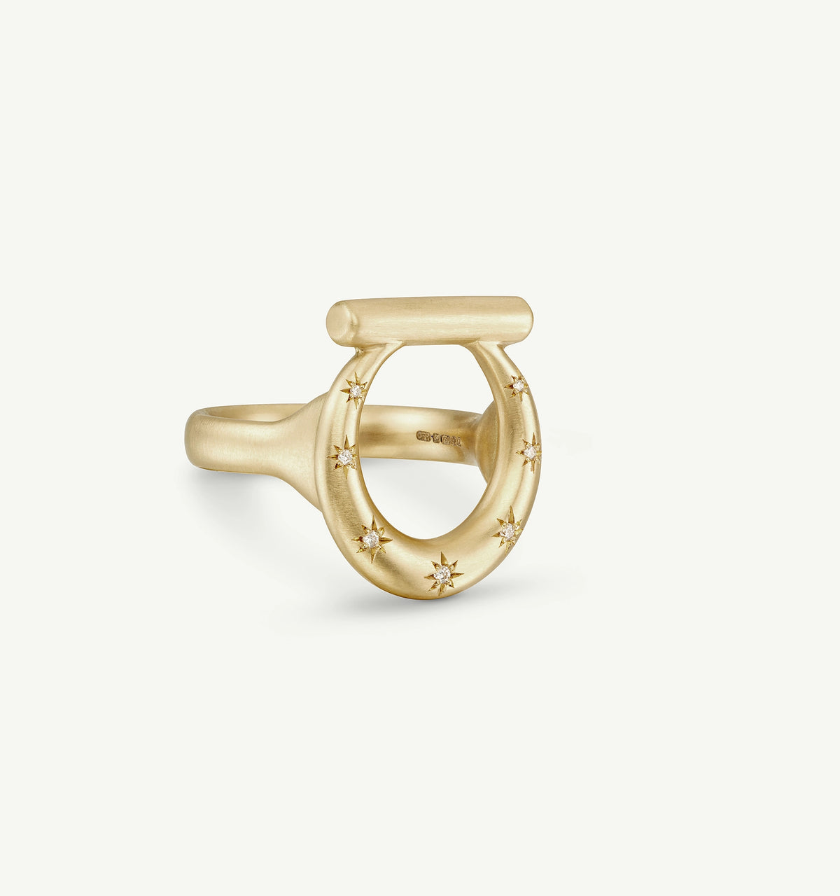 Gold ring featuring a circular design with engraved stars around the band.