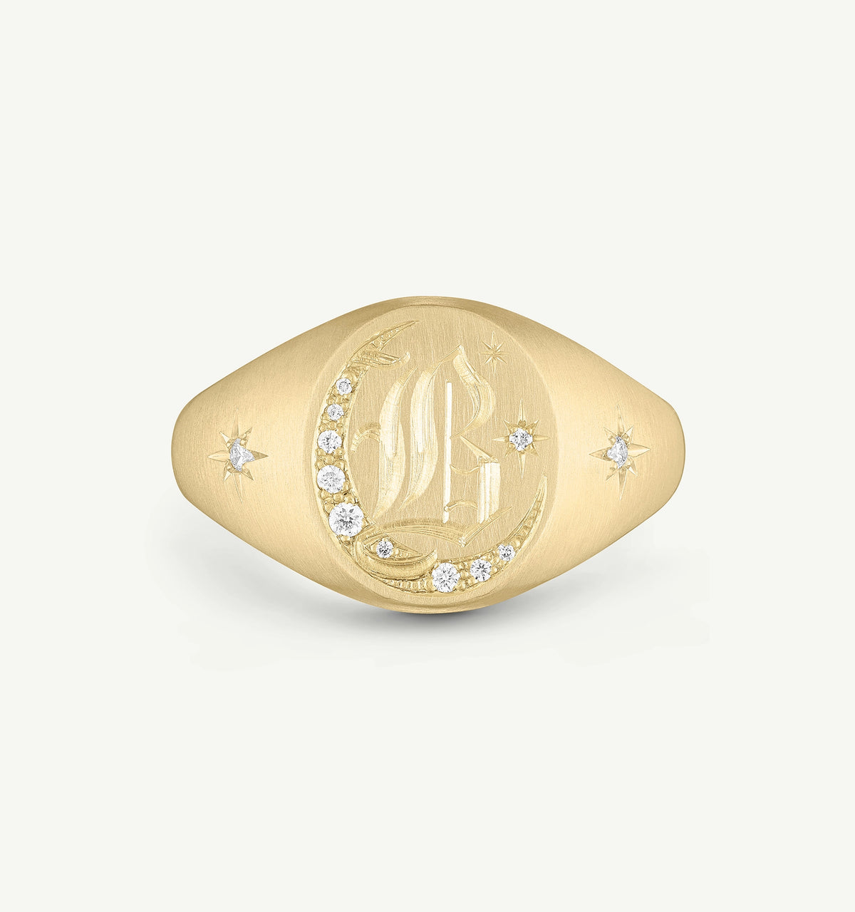 Gold signet ring featuring an engraved moon and star design with diamond accents.