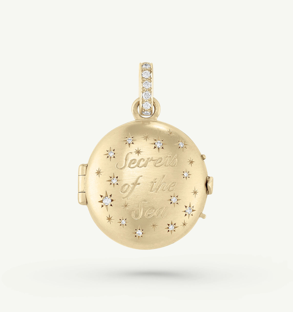 Gold locket with "Secrets of the Sea" engraving and diamond accents in star shapes.