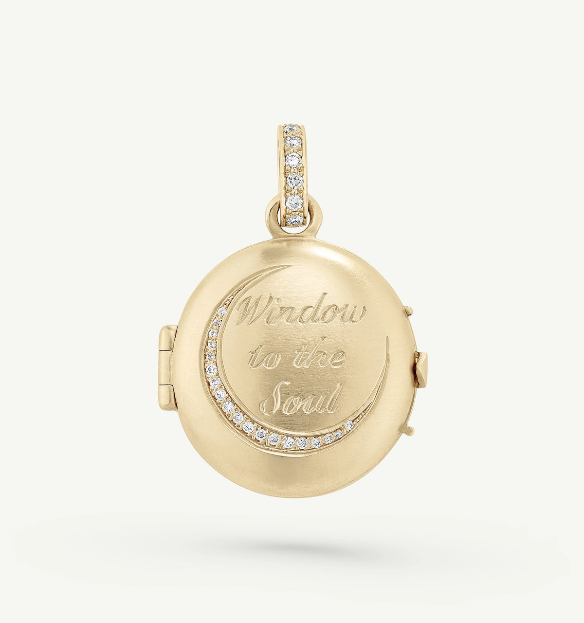 Gold locket pendant featuring the engraving "Window to the Soul" and accented with diamonds along the edge.
