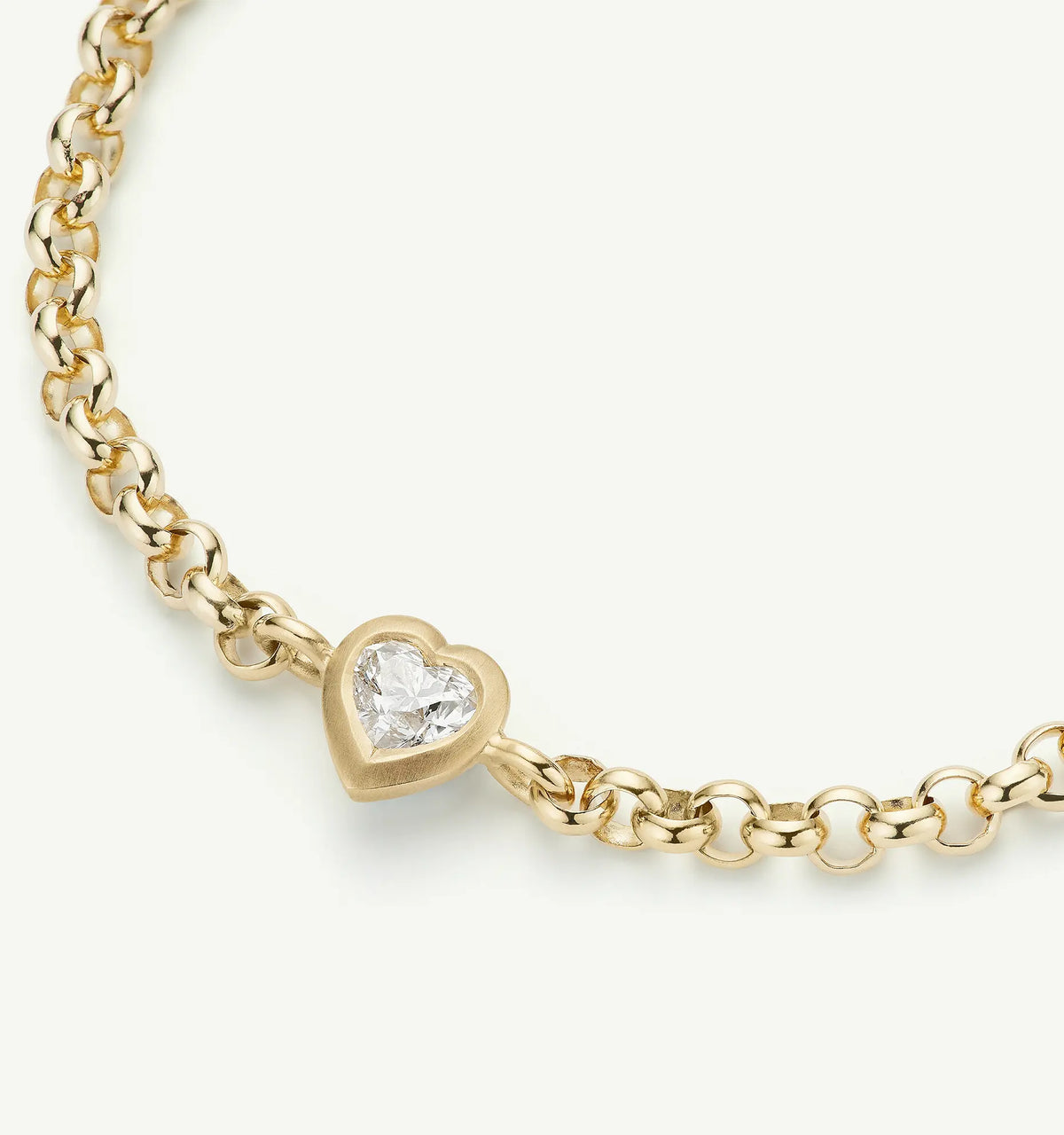 Gold bracelet featuring a heart-shaped pendant with a diamond.