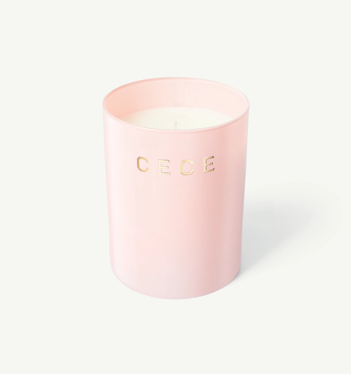 Candle in a soft pink holder with gold "CECE" lettering against a light background.