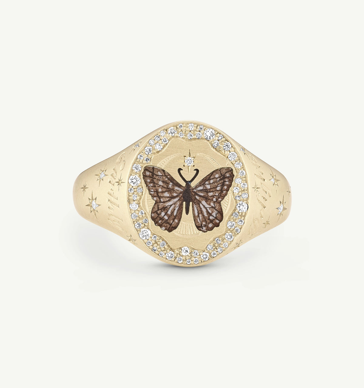 Gold signet ring featuring a butterfly design surrounded by white diamonds and engraved star motifs.