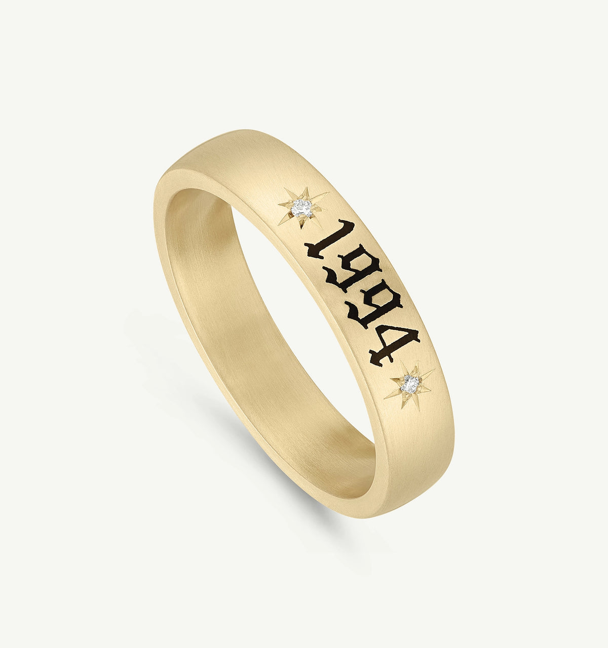 Gold ring engraved with "1994" and featuring two small diamonds on either side.