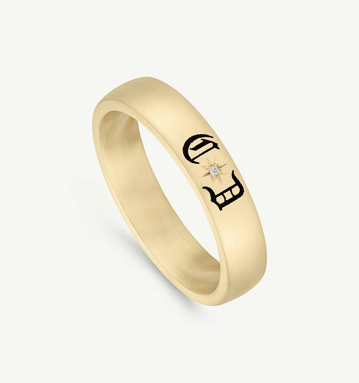 Gold ring featuring engraved black motifs and a small diamond accent.