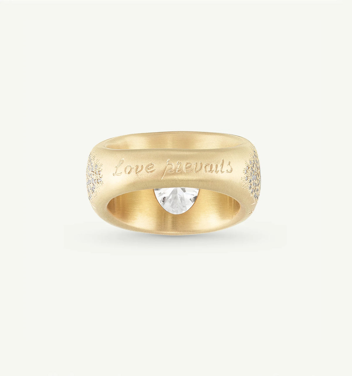 Gold ring featuring an engraved "Love prevails" inscription and a central diamond.