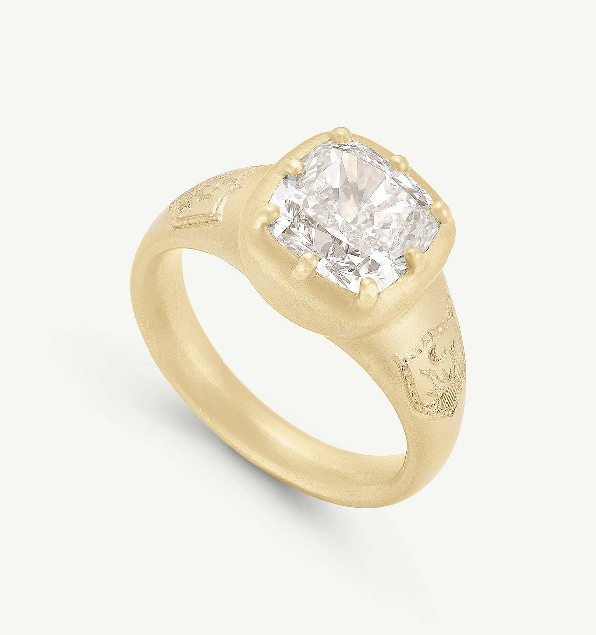 Gold ring featuring a large cushion-cut diamond and engraved details on the band.