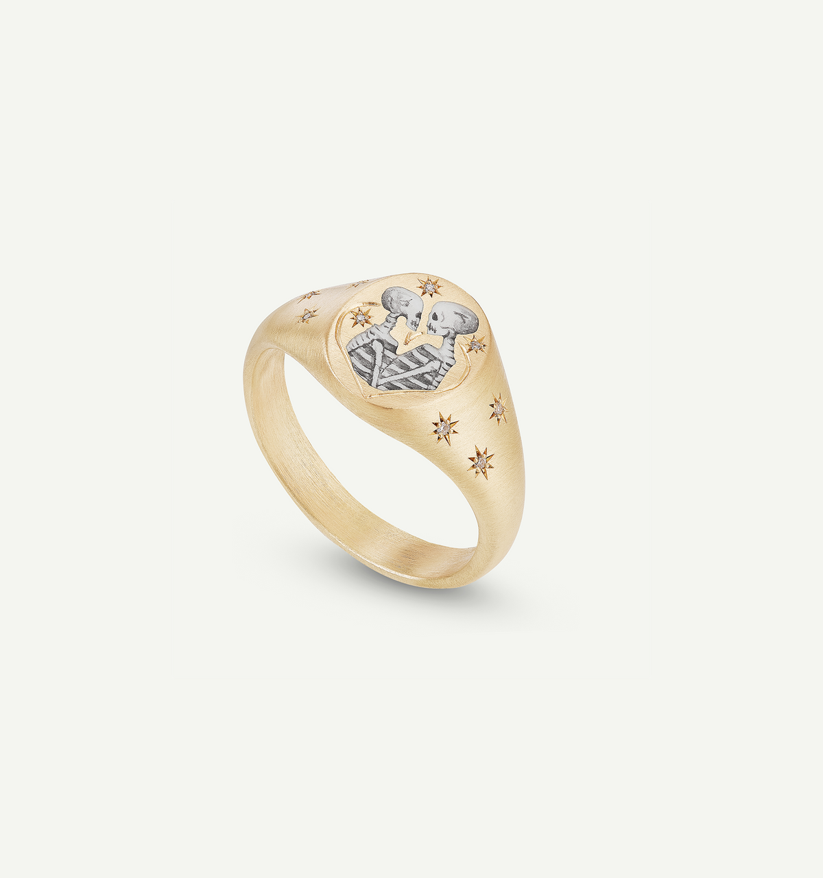Gold signet ring featuring an engraved design with two figures and star motifs.