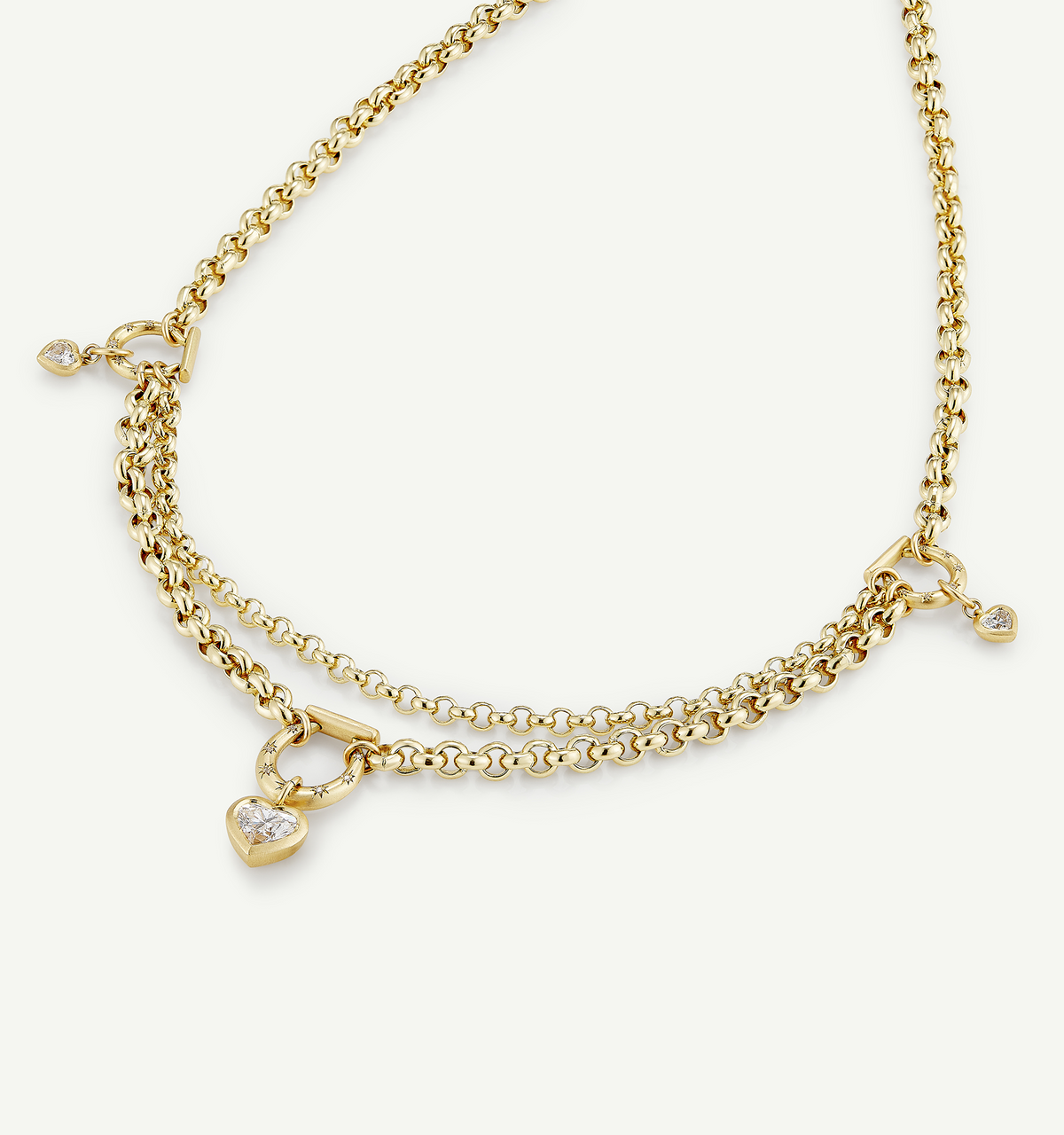 Gold layered necklace featuring heart pendant and small accents.