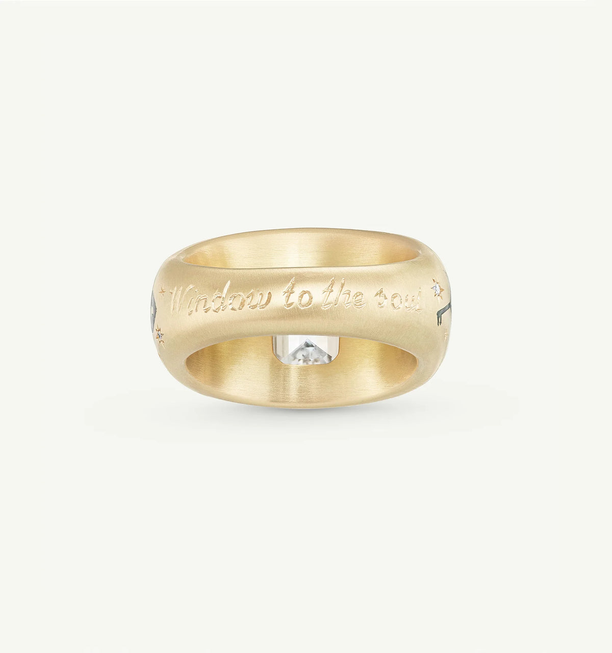Gold ring engraved with "Window to the soul," featuring a clear diamond in a decorative setting.