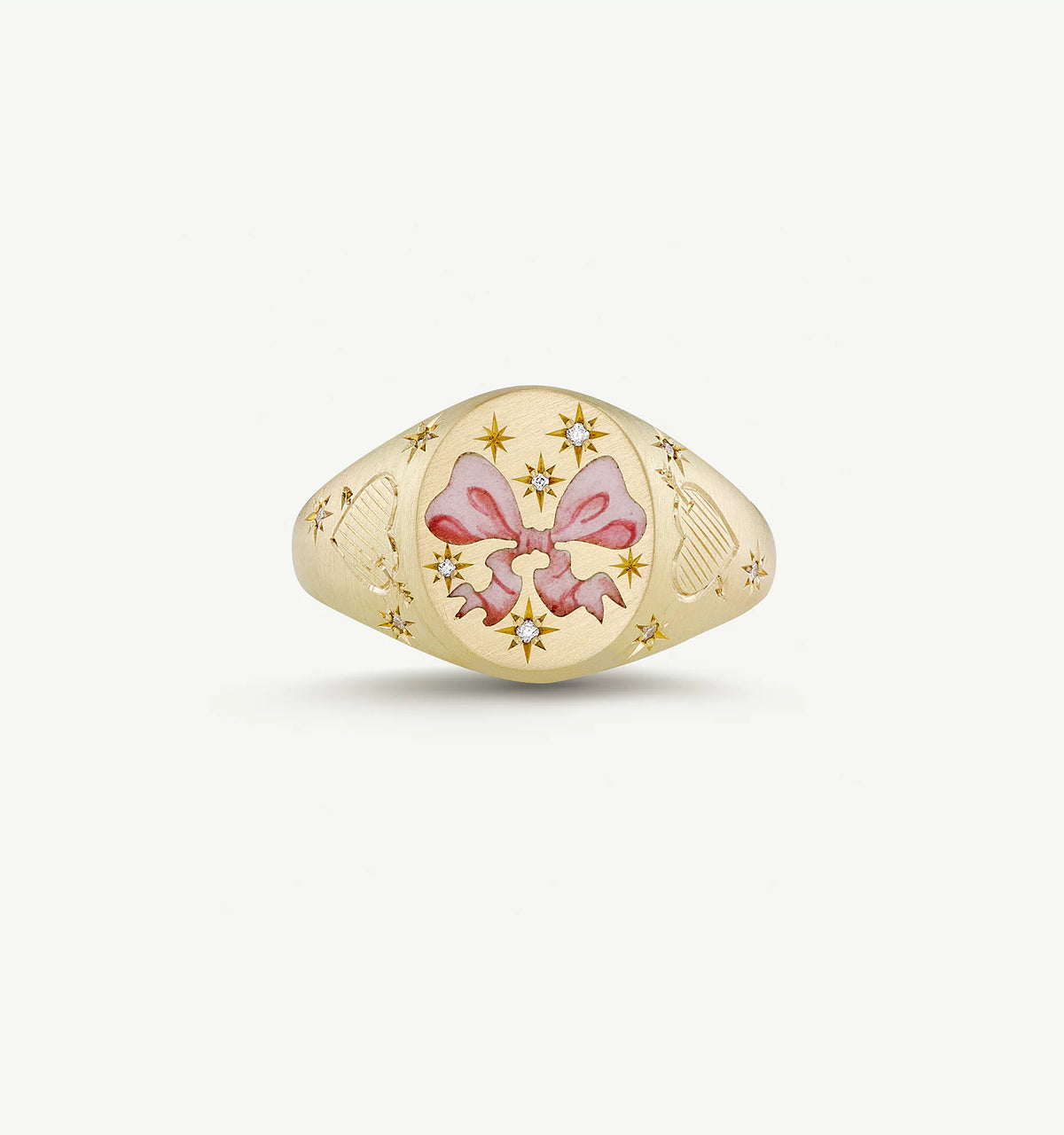 Gold ring featuring a pink bow in enamel and accented with small diamonds.