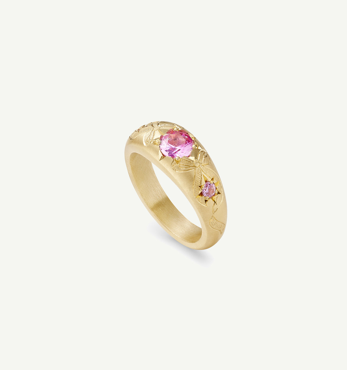 Gold ring featuring pink sapphires with intricate floral engravings.