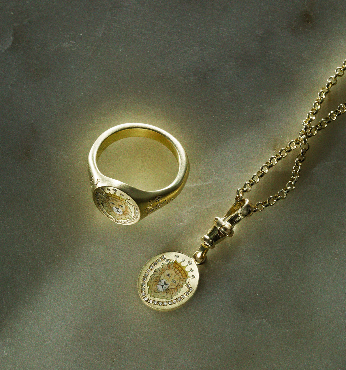Gold ring featuring a lion emblem and gold pendant on a chain with a lion motif.