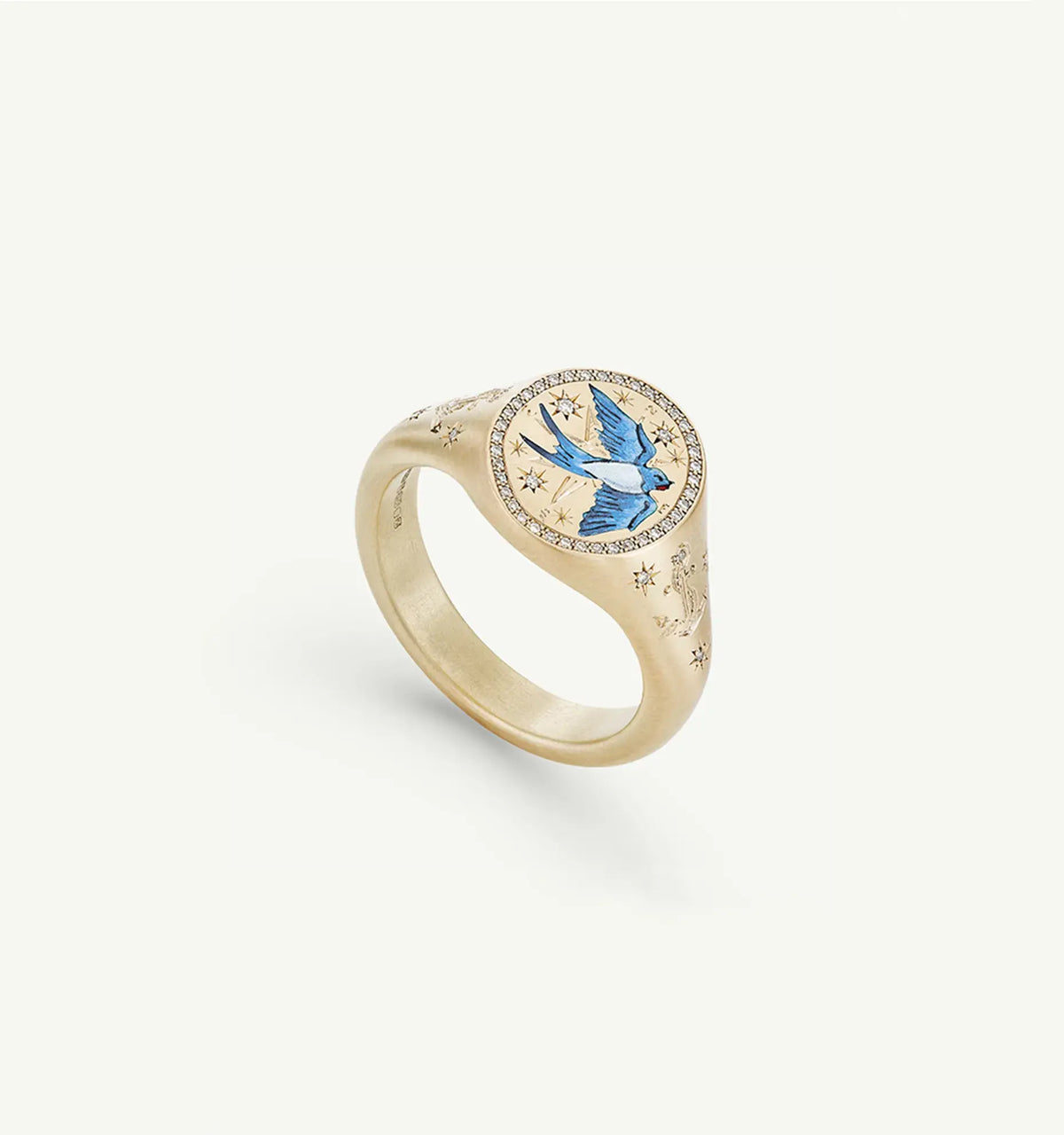 Gold ring featuring a blue enamel bird design and star motifs, with small diamonds around the top.