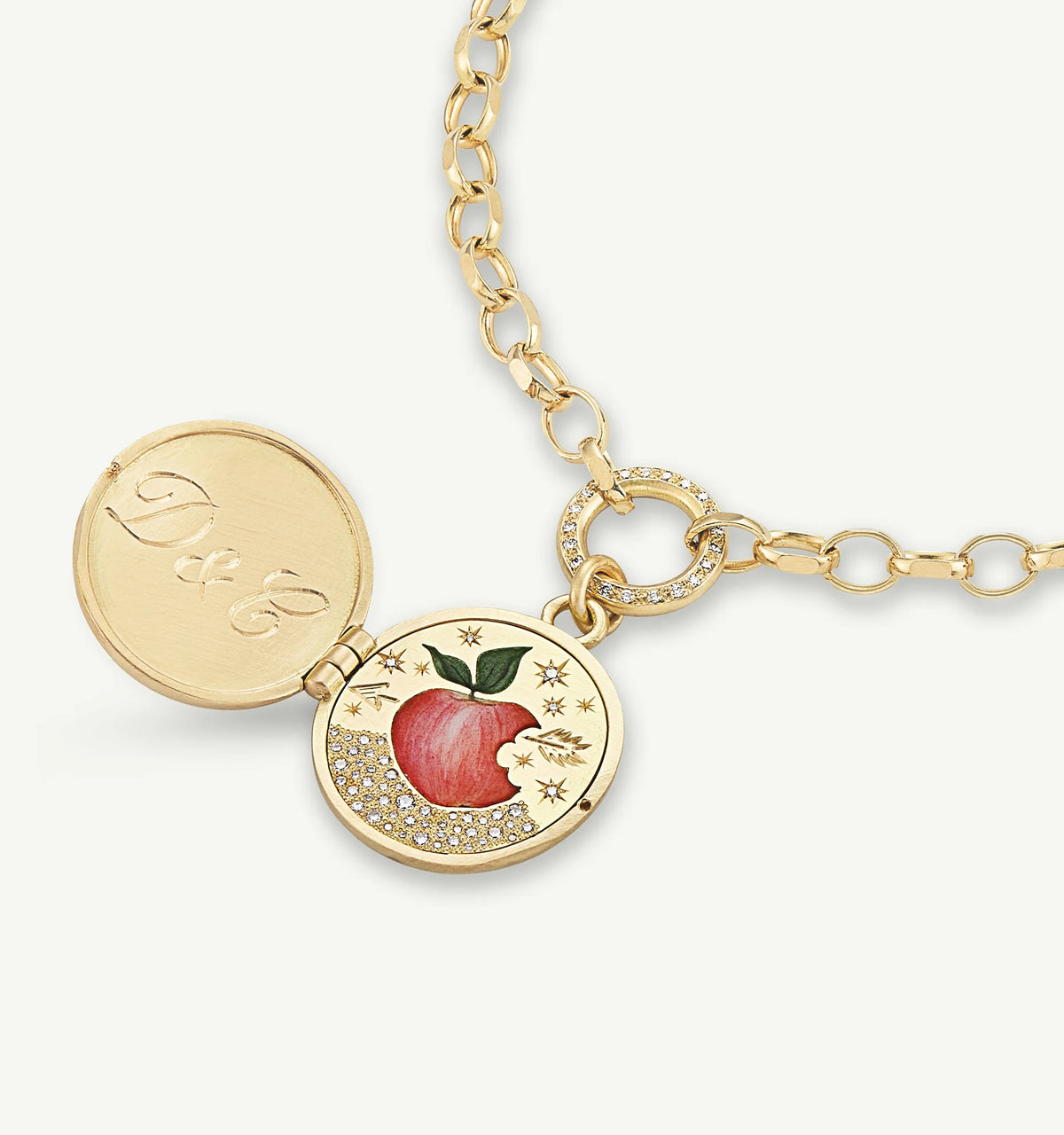 Gold locket necklace with an apple motif in enamel and diamond accents, featuring an engraved interior.