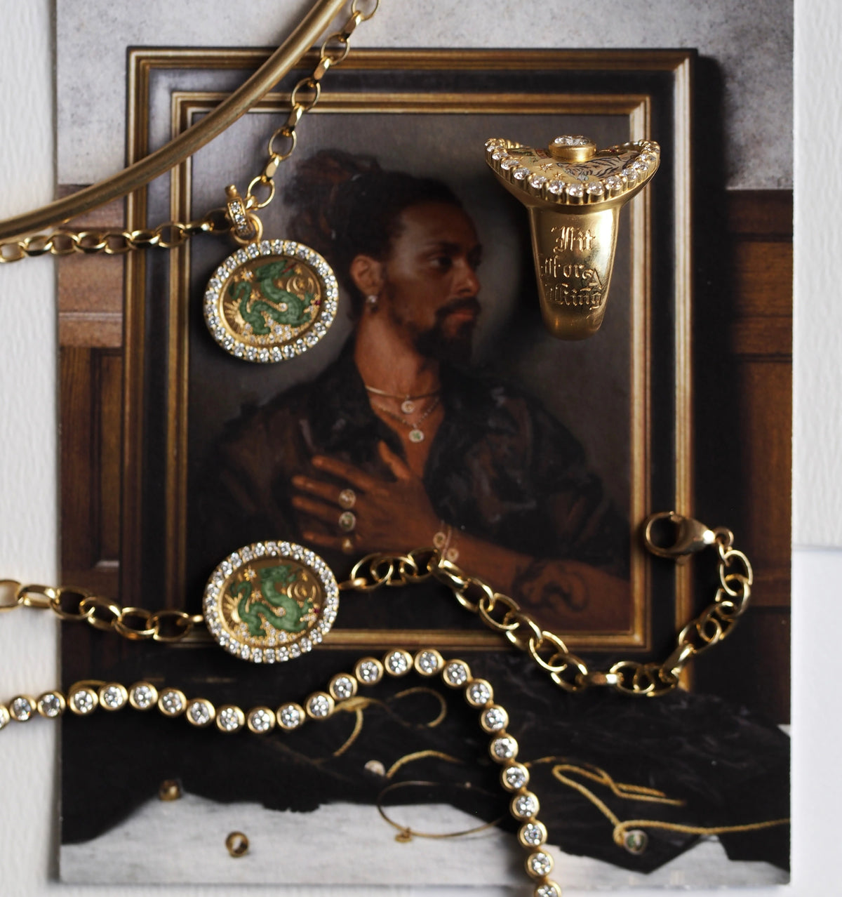 Gold chain necklace with green enamel pendant and cubic zirconia accents on a portrait backdrop. Gold ring with diamonds above.