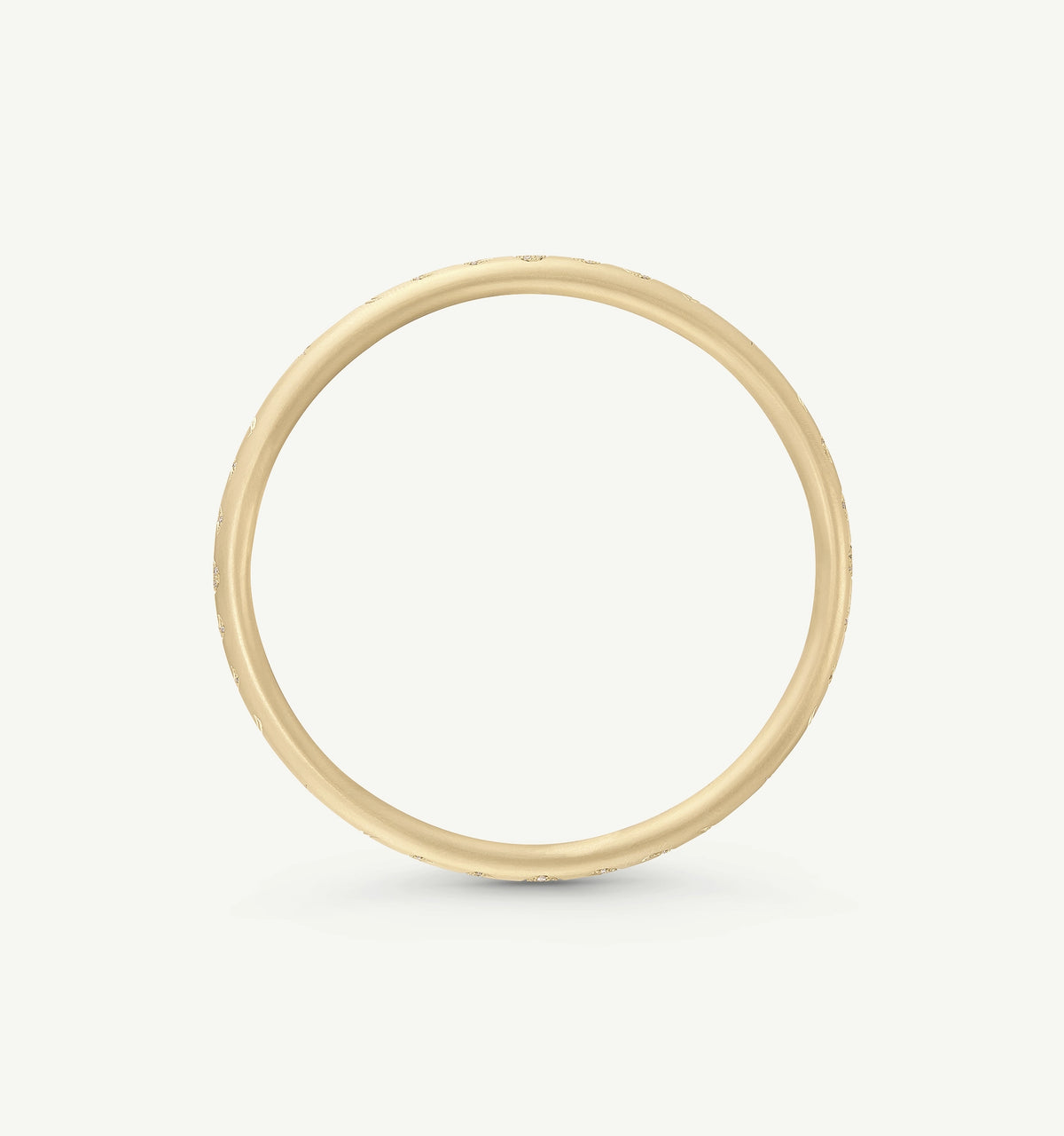 Gold ring with a textured surface, set against a light background.