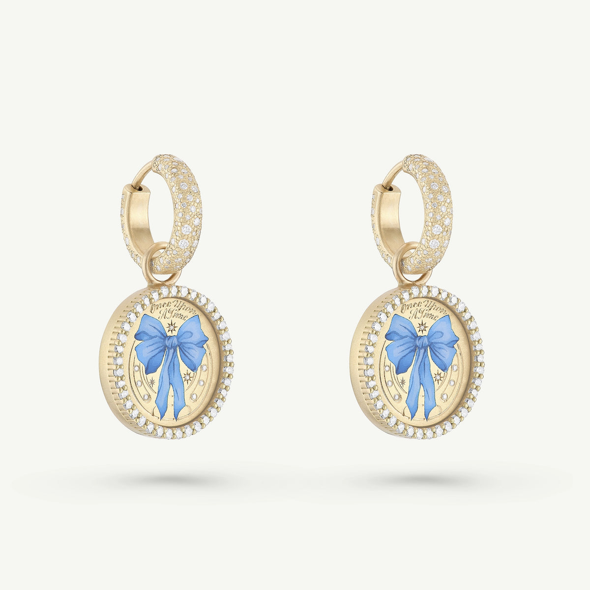 Gold hoop earrings featuring a blue bow design in enamel, surrounded by a halo of small diamonds.