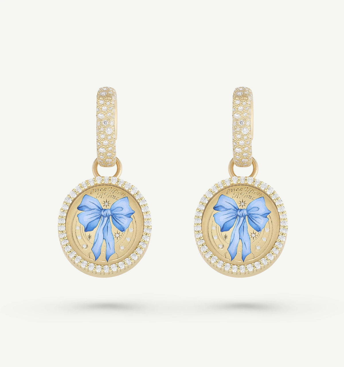 Gold earrings featuring blue enamel bows and surrounded by a halo of diamonds.