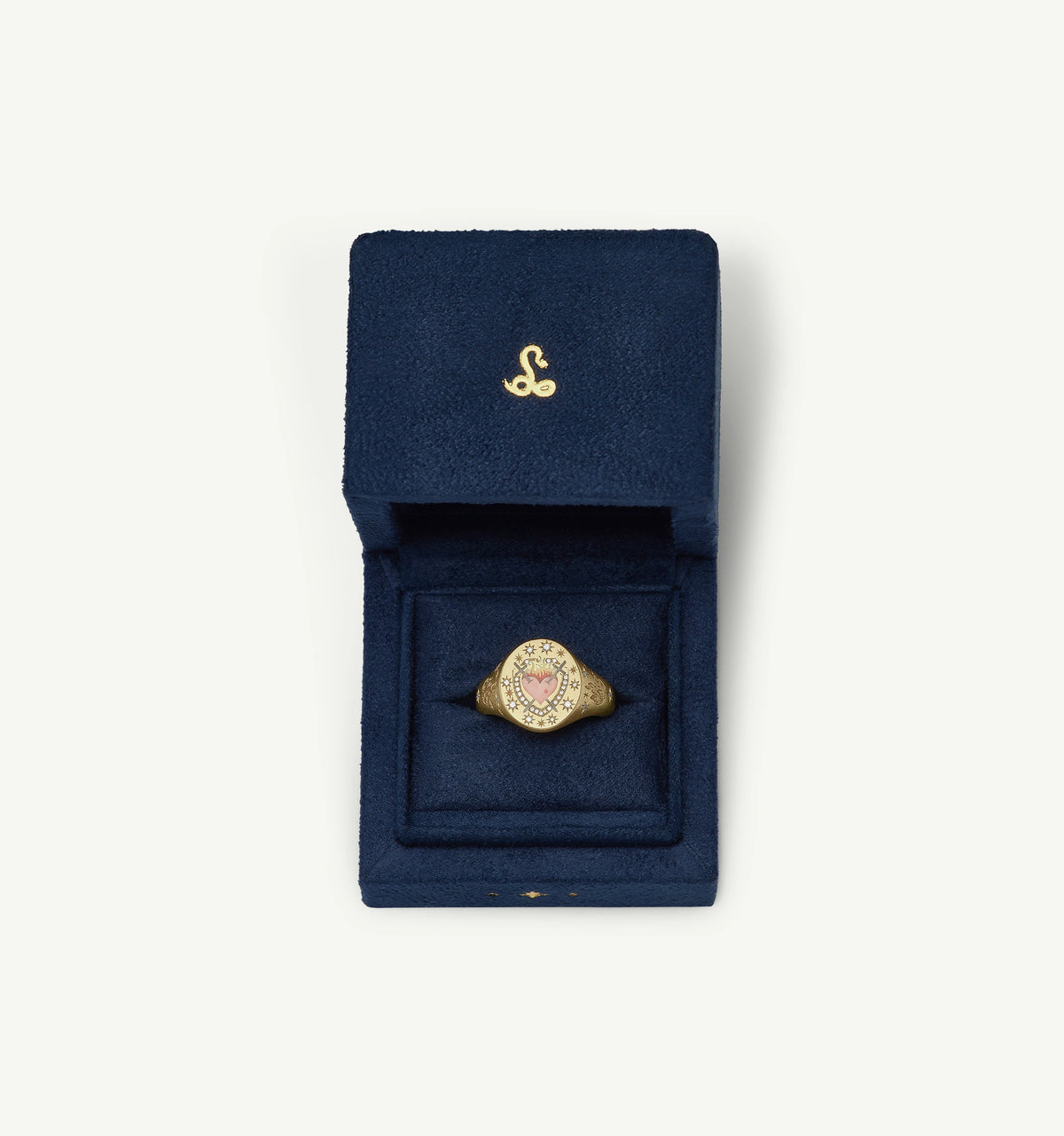 Gold signet ring featuring a pink heart design in enamel, presented in a navy blue velvet box.