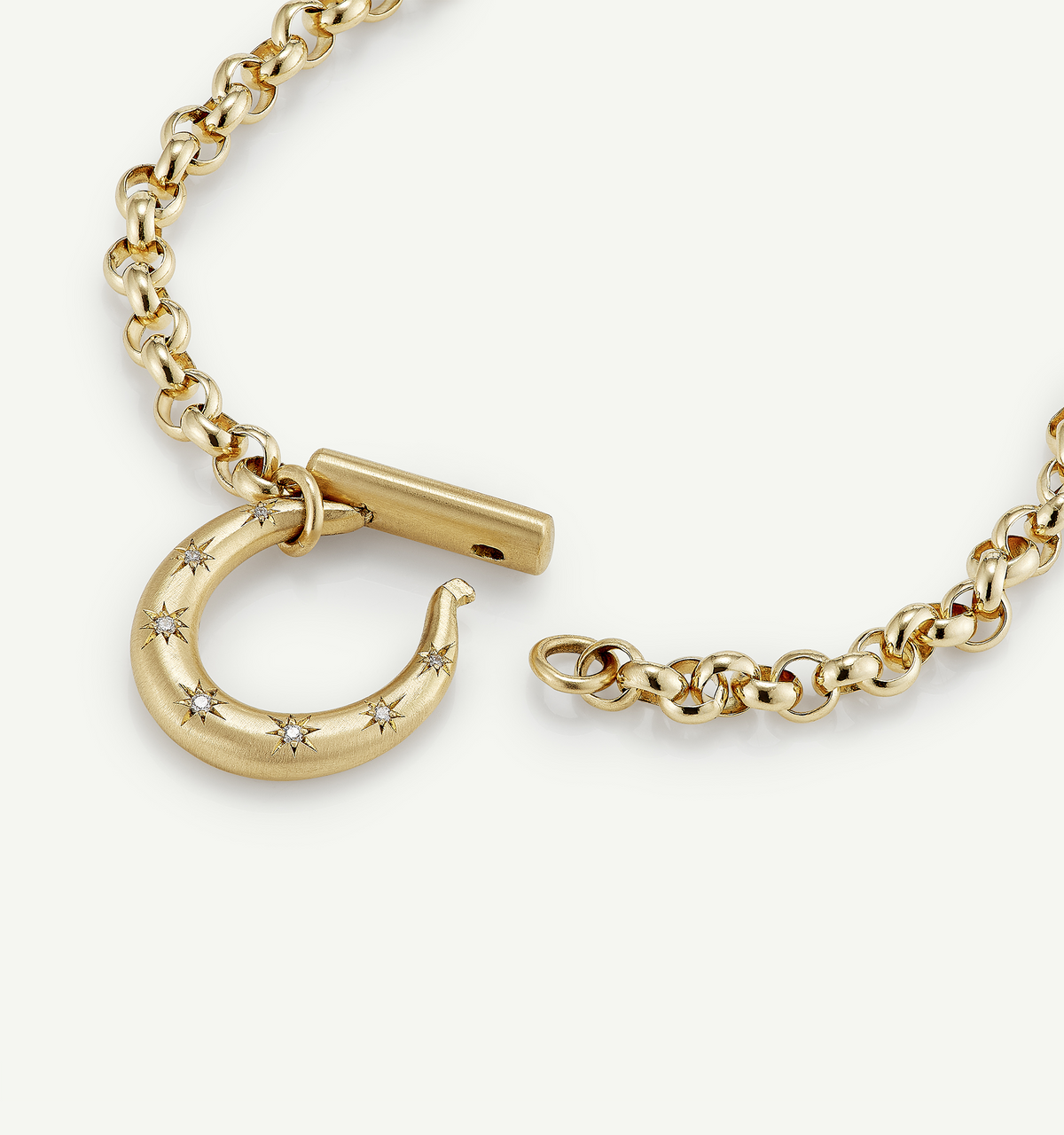 Gold necklace featuring a hook clasp with small star-shaped diamonds arranged along the curve.