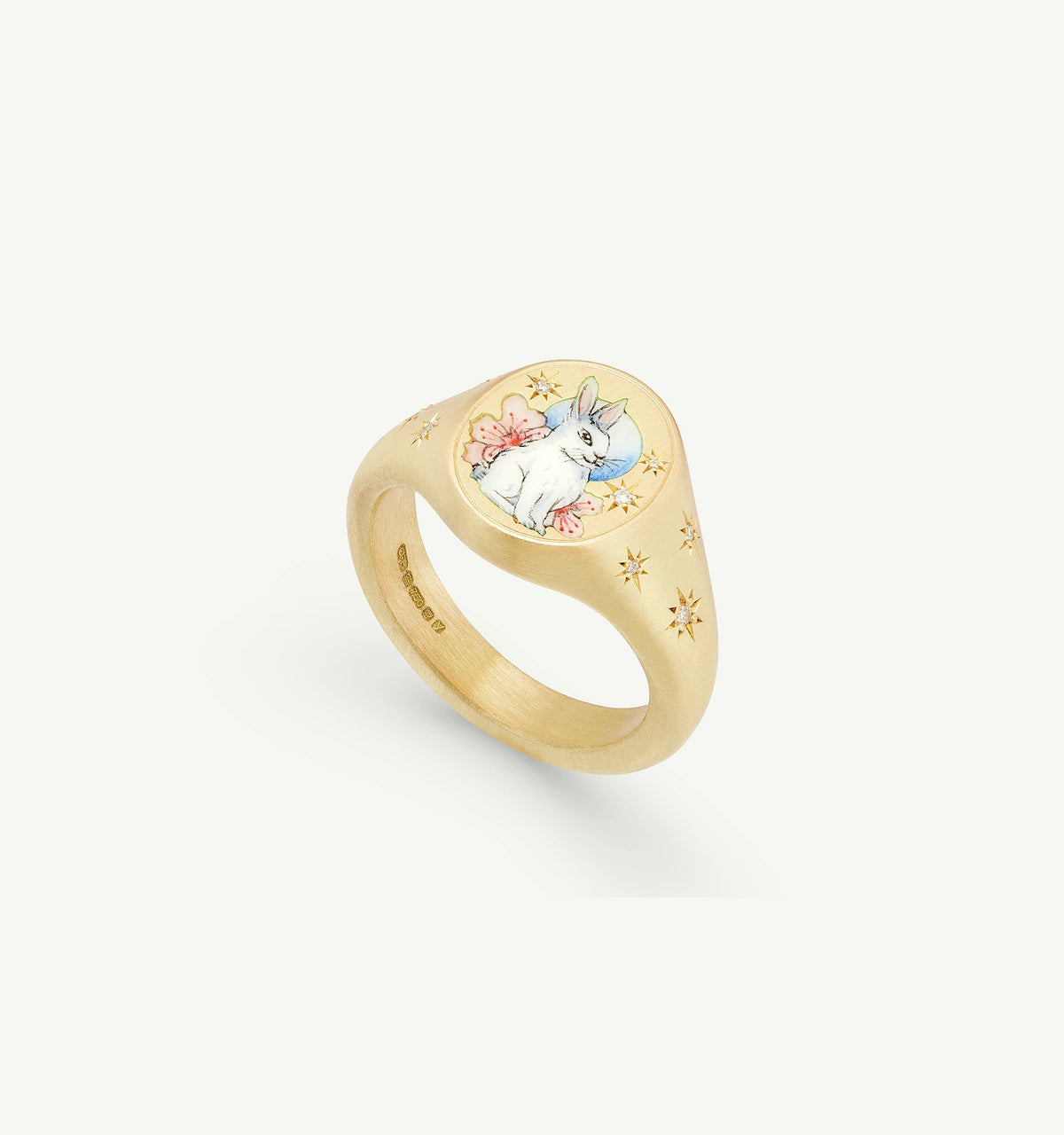Gold ring featuring a painted rabbit design and engraved star motifs.