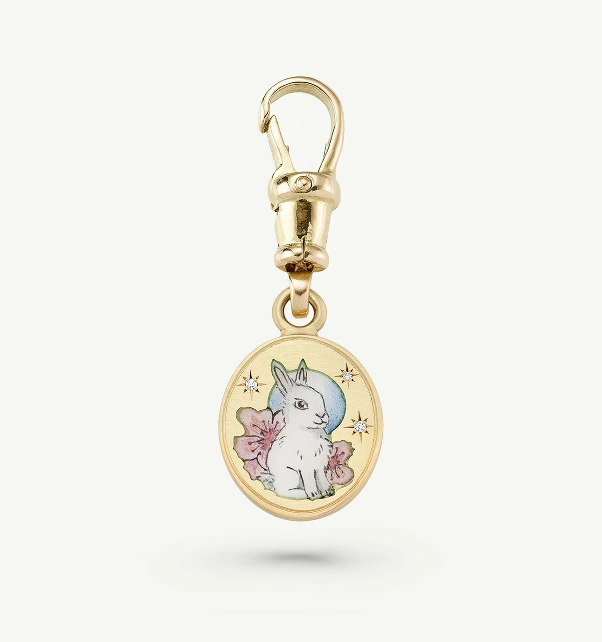 Gold charm featuring an illustrated rabbit and floral motif with two small diamonds.