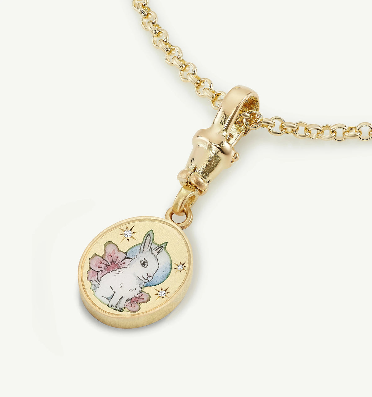 Gold pendant featuring a bunny illustration with flowers and small stars in enamel on a chain.