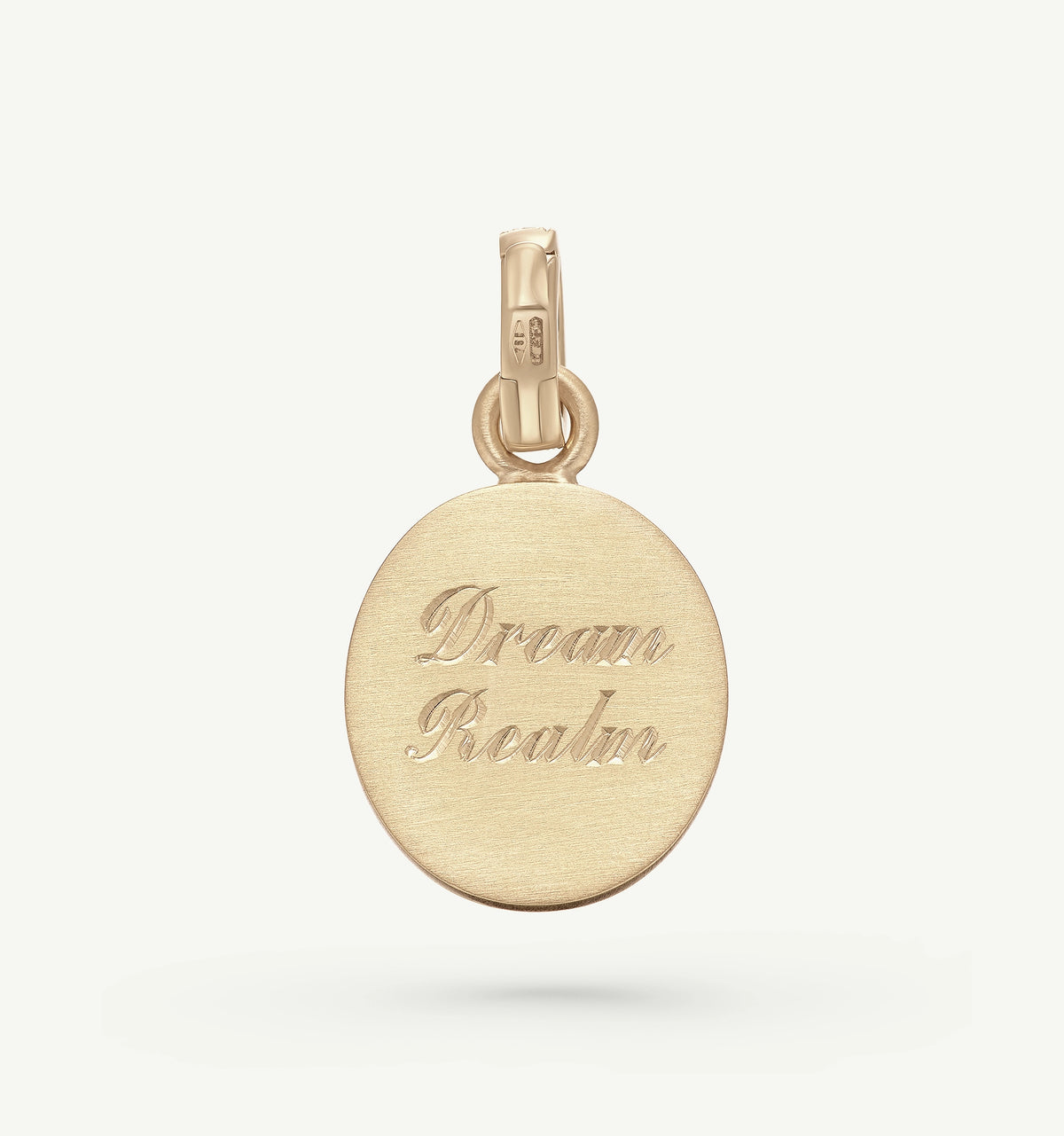 Gold pendant engraved with "Dream Realm" on a smooth round surface.