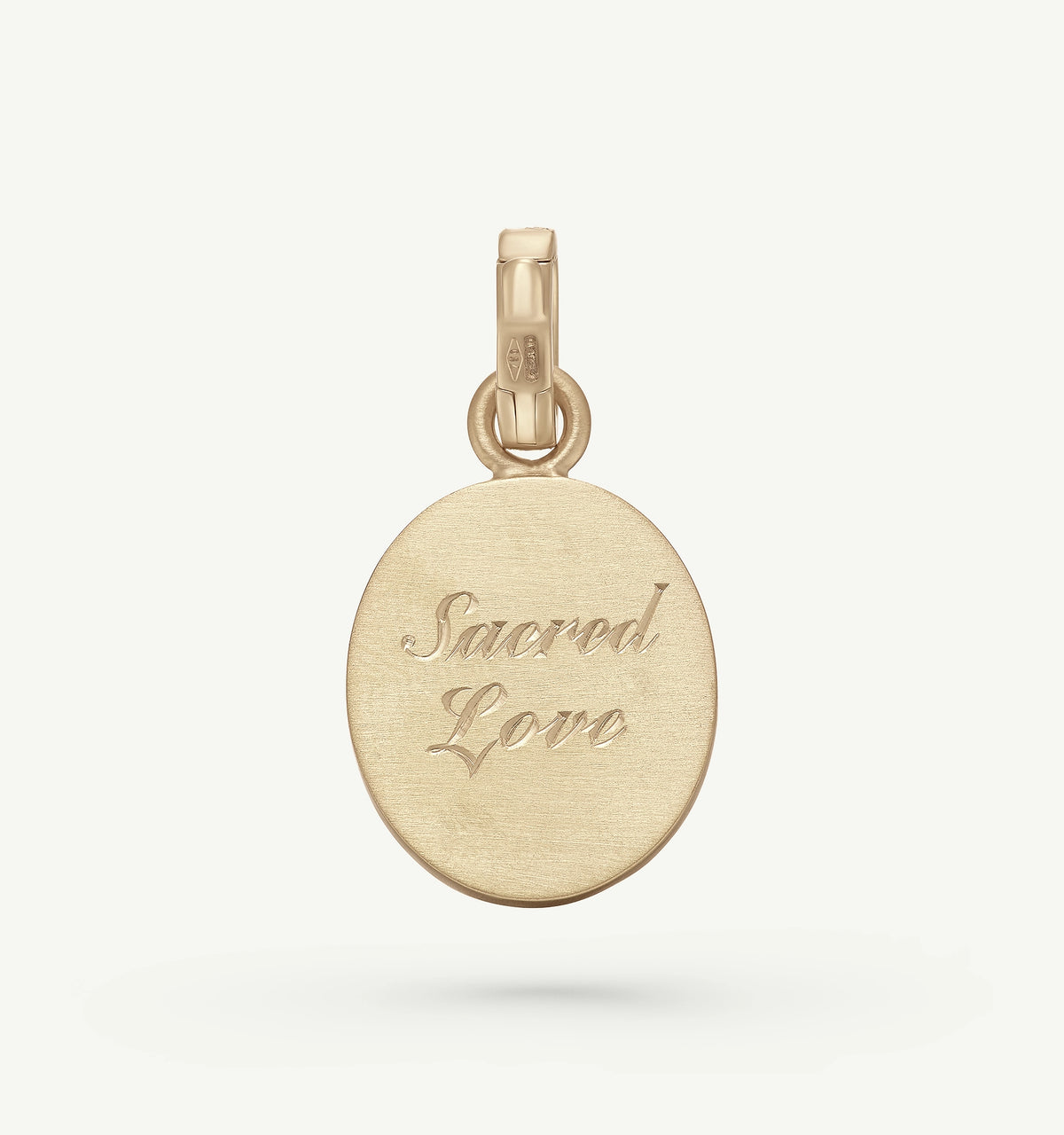 Gold pendant featuring the engraved text "Sacred Love."