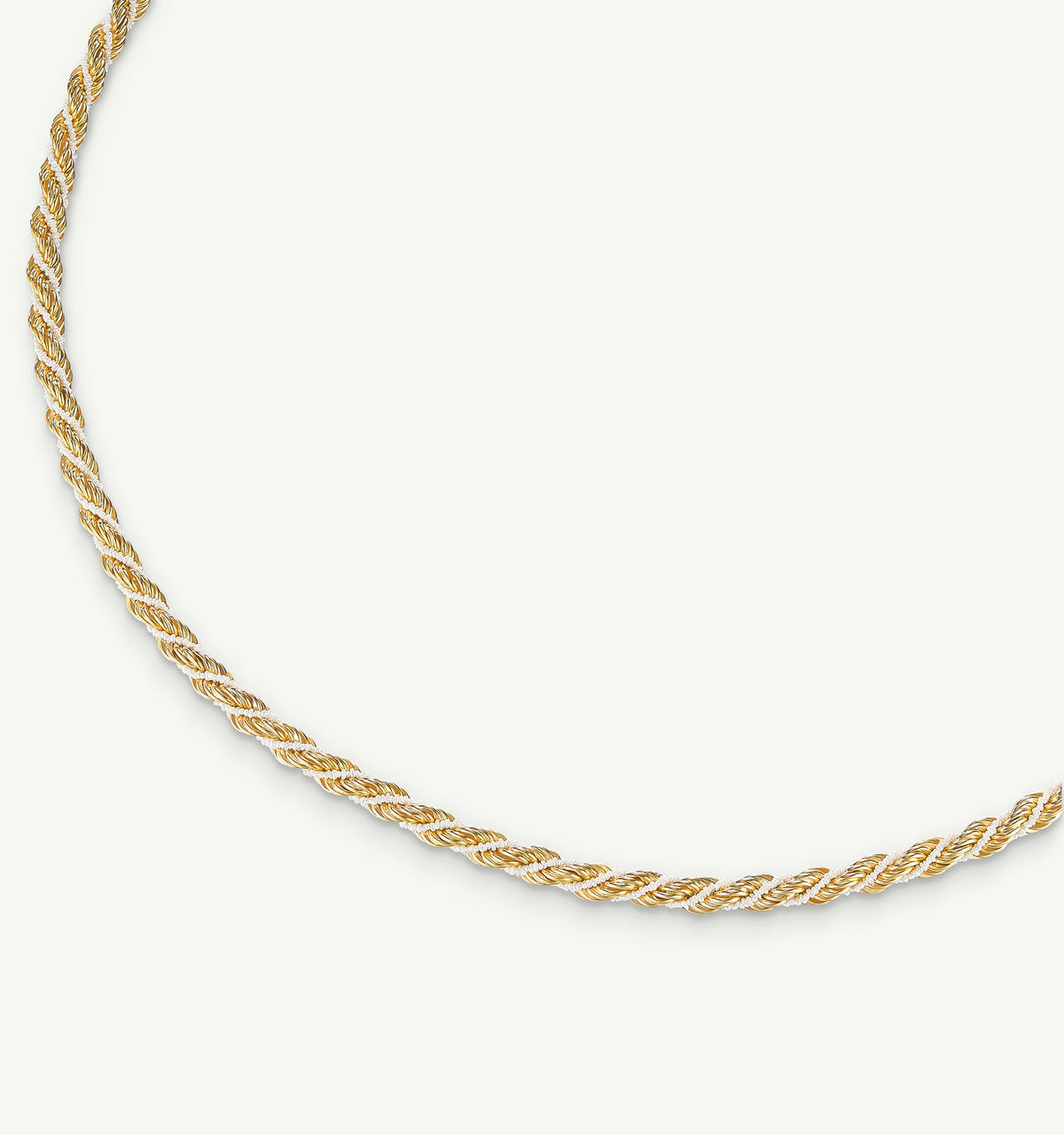 Twisted gold necklace on a light background.