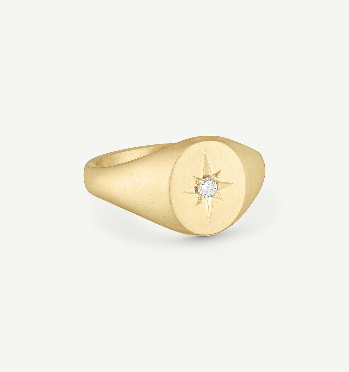 Gold signet ring featuring a star design with a diamond at the centre.